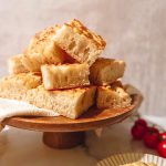 A wooden plate of garlic topped Lebanese talami bread.